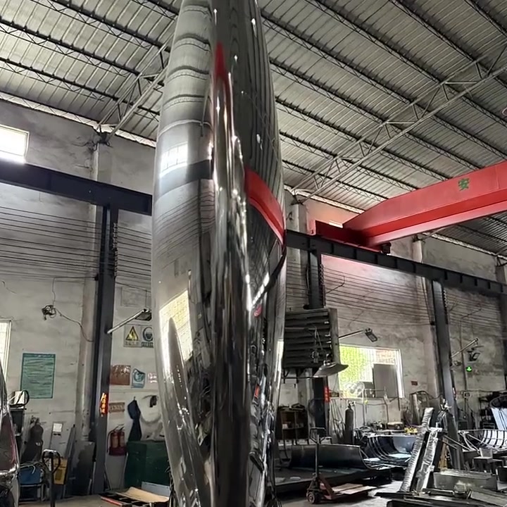 Edge-on view of the ring sculpture showing the seamless double-curved profile of the polished stainless steel band