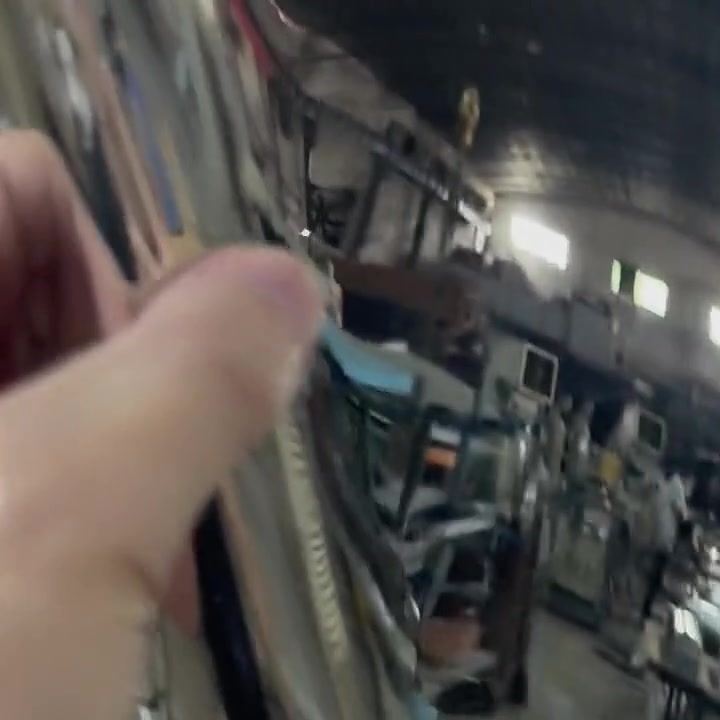 Macro detail of a fingertip on the mirror-polished surface showing how clearly the reflection resolves in the finish